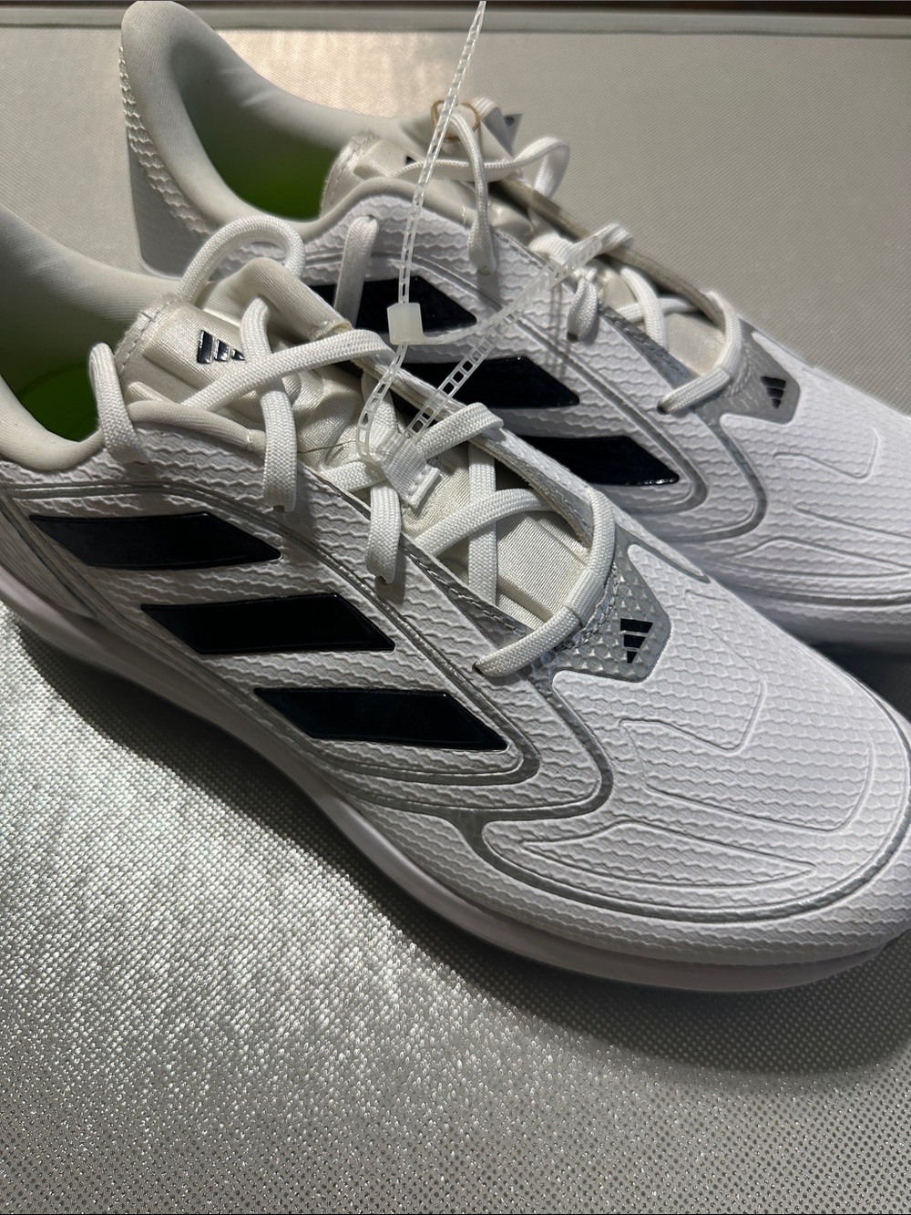 adidas women’s White metal cleats with Black Stripes